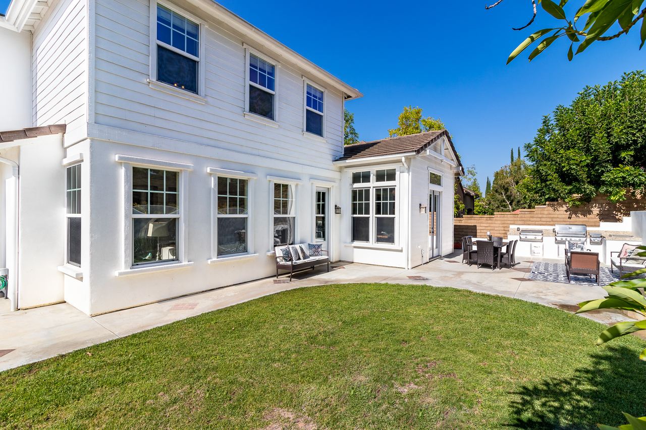 Backyard lawn behind a white two-story home