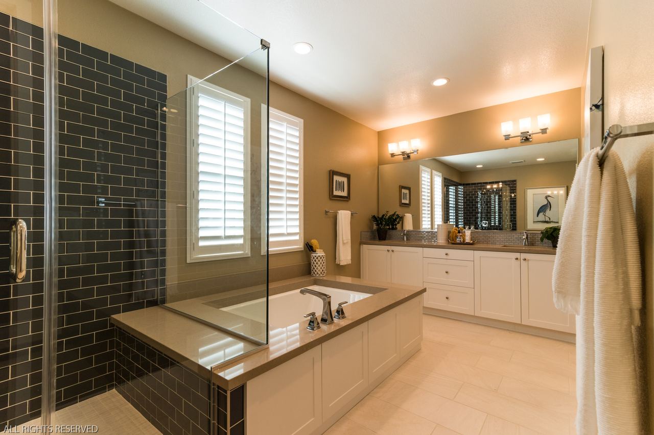 Primary bath with a soaking tub and a dark-tiled walk-in shower