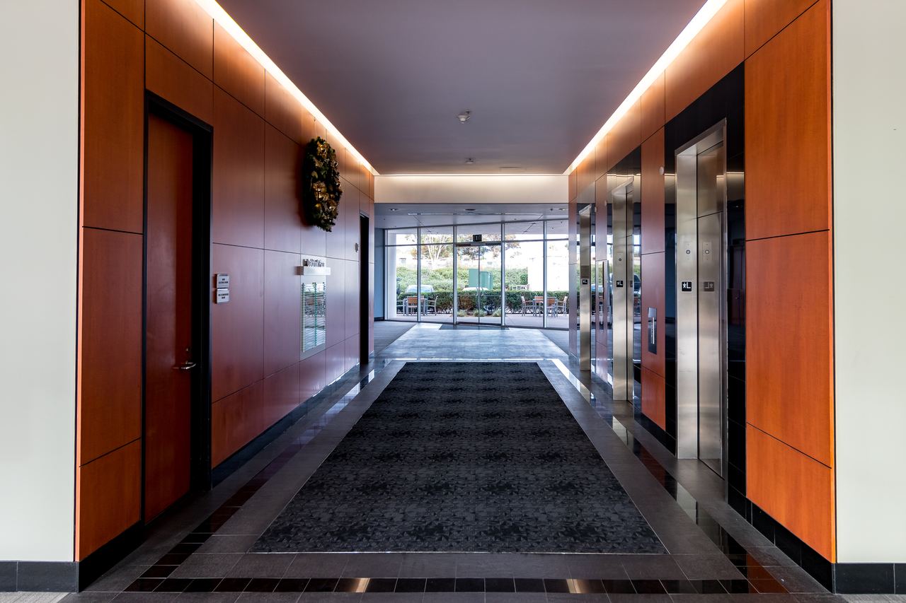 Office corridor with orange accent walls and a long patterned runner