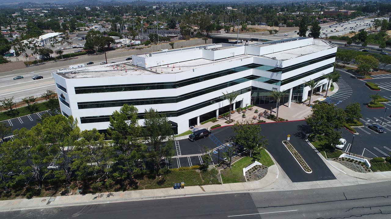 Aerial drone view of an office building at the base of the hills