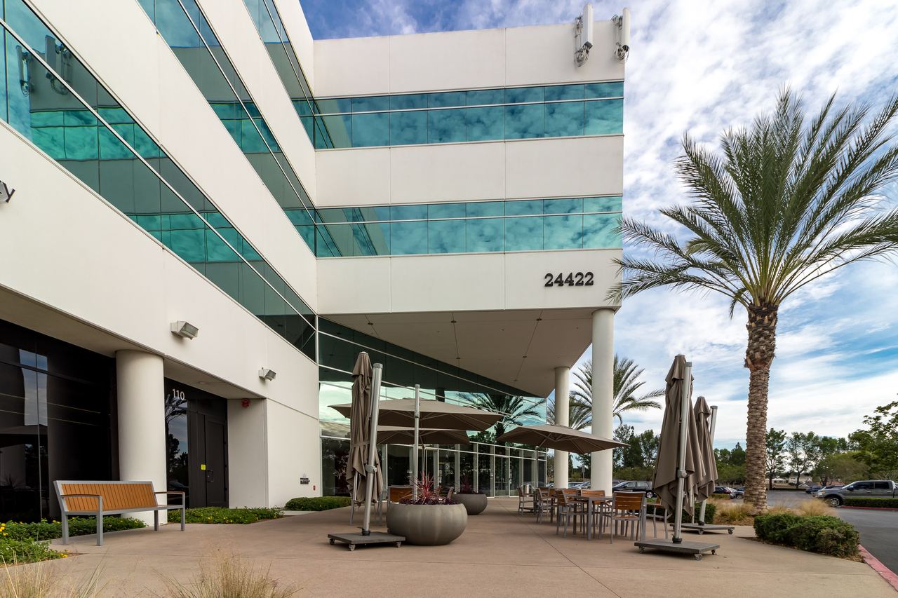 Office building entry with palms and a shaded courtyard