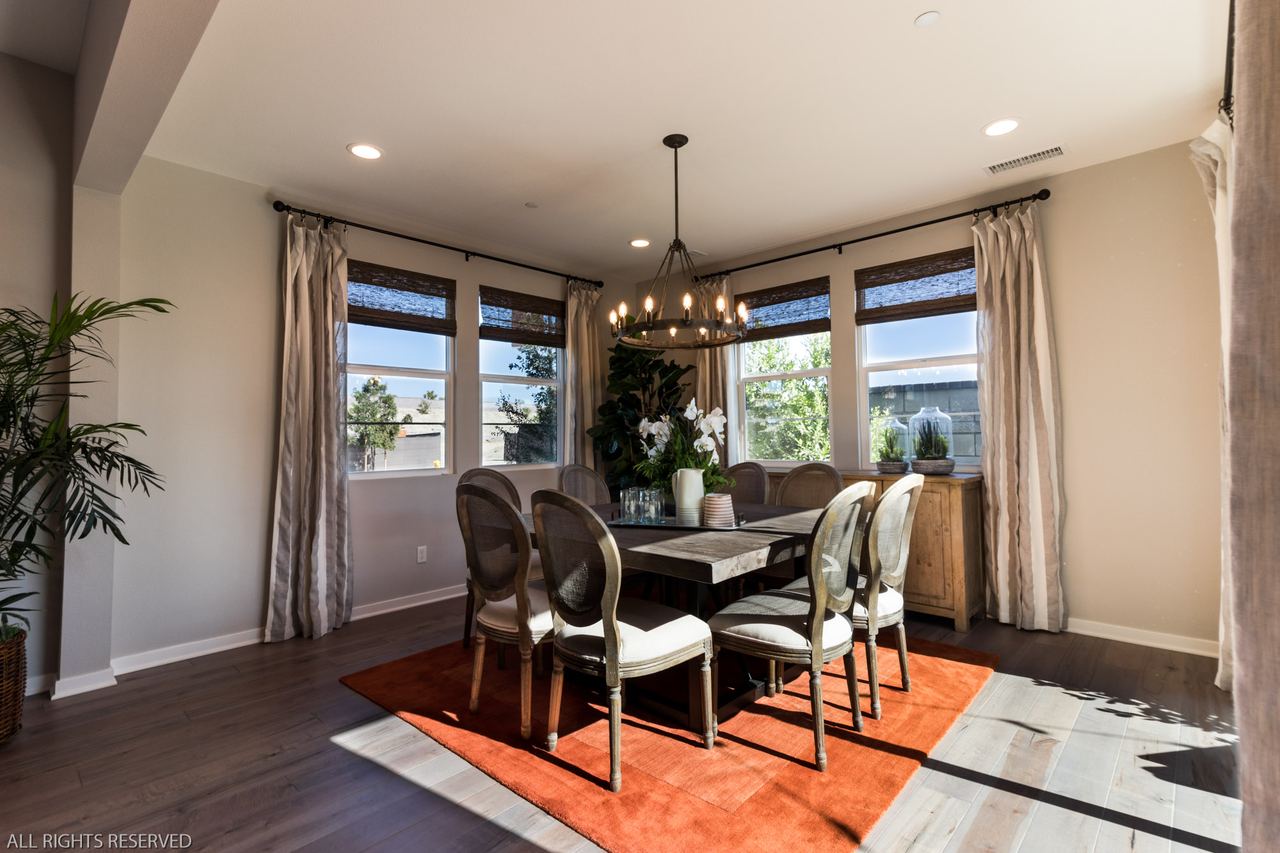 Formal dining room with a wrought-iron chandelier and a patterned rug