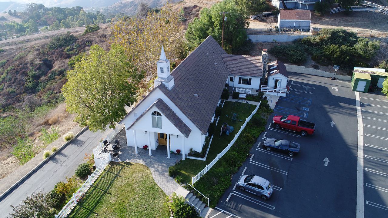 Aerial drone view of a hillside church and parking lot