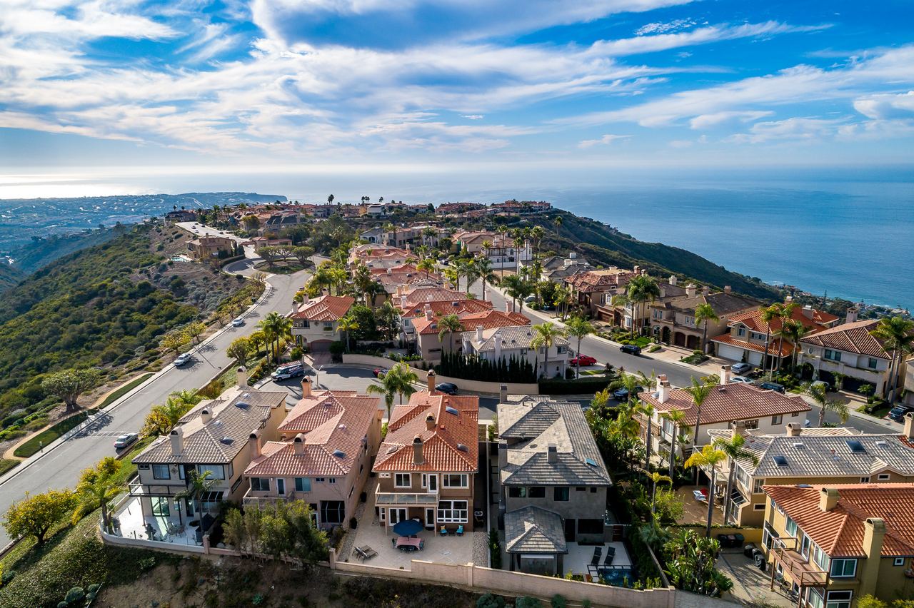 Aerial drone view of a hillside neighborhood overlooking the ocean
