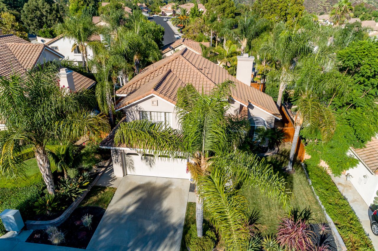 Aerial drone view of a home on a tree-lined street