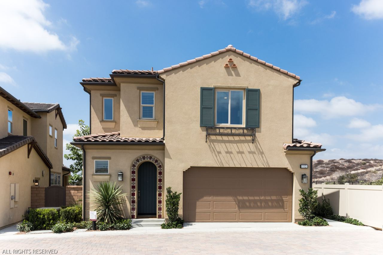 Two-story home exterior under a clear blue sky