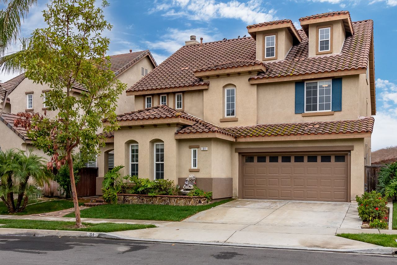 Two-story home with a manicured front yard and blue sky