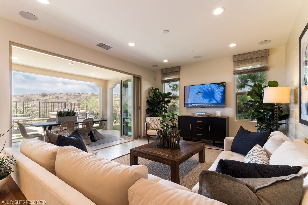 Coastal-styled living room with a sliding glass wall to the back patio