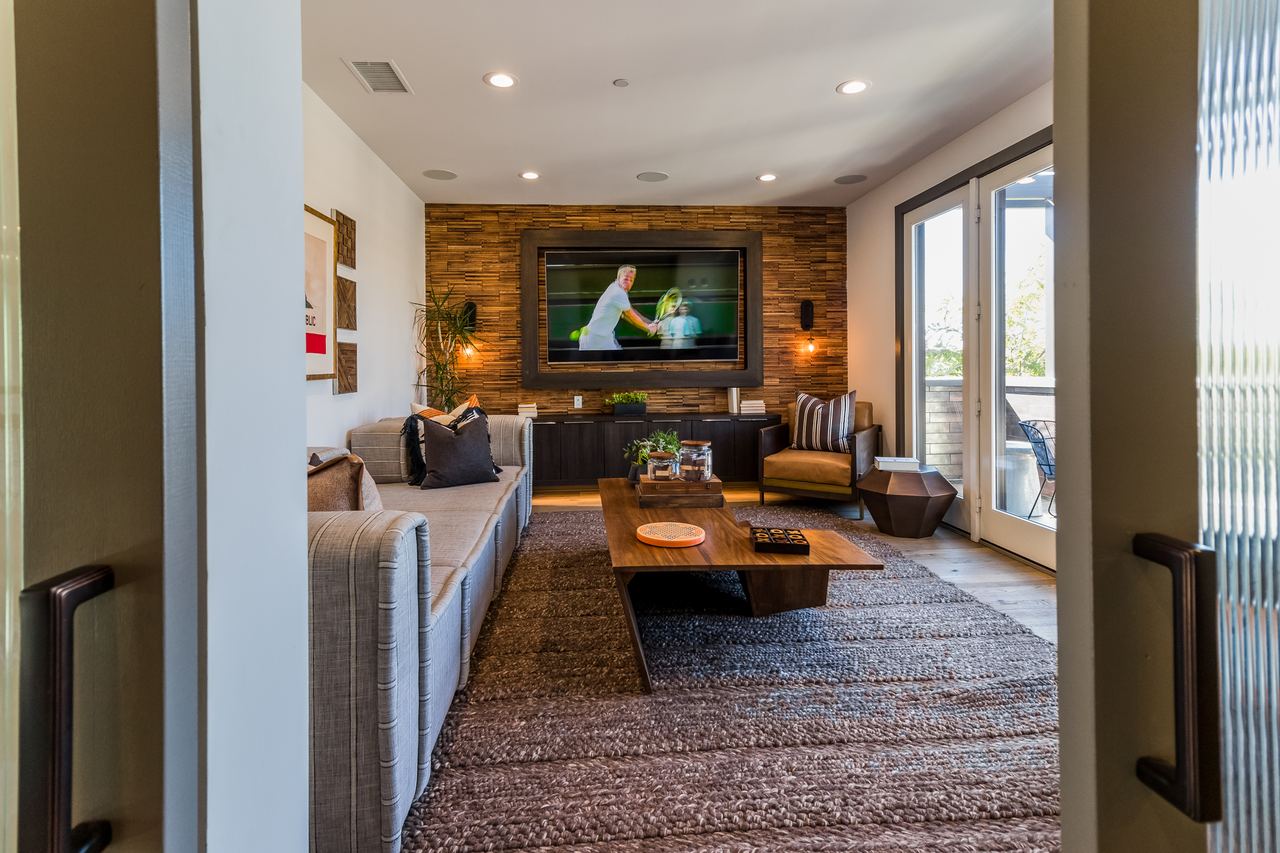 Cozy media room with a wood feature wall and leather seating